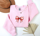 a pink sweater with a bow and hearts on it