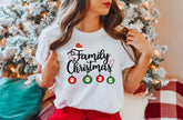 a woman wearing a family christmas t - shirt in front of a christmas tree