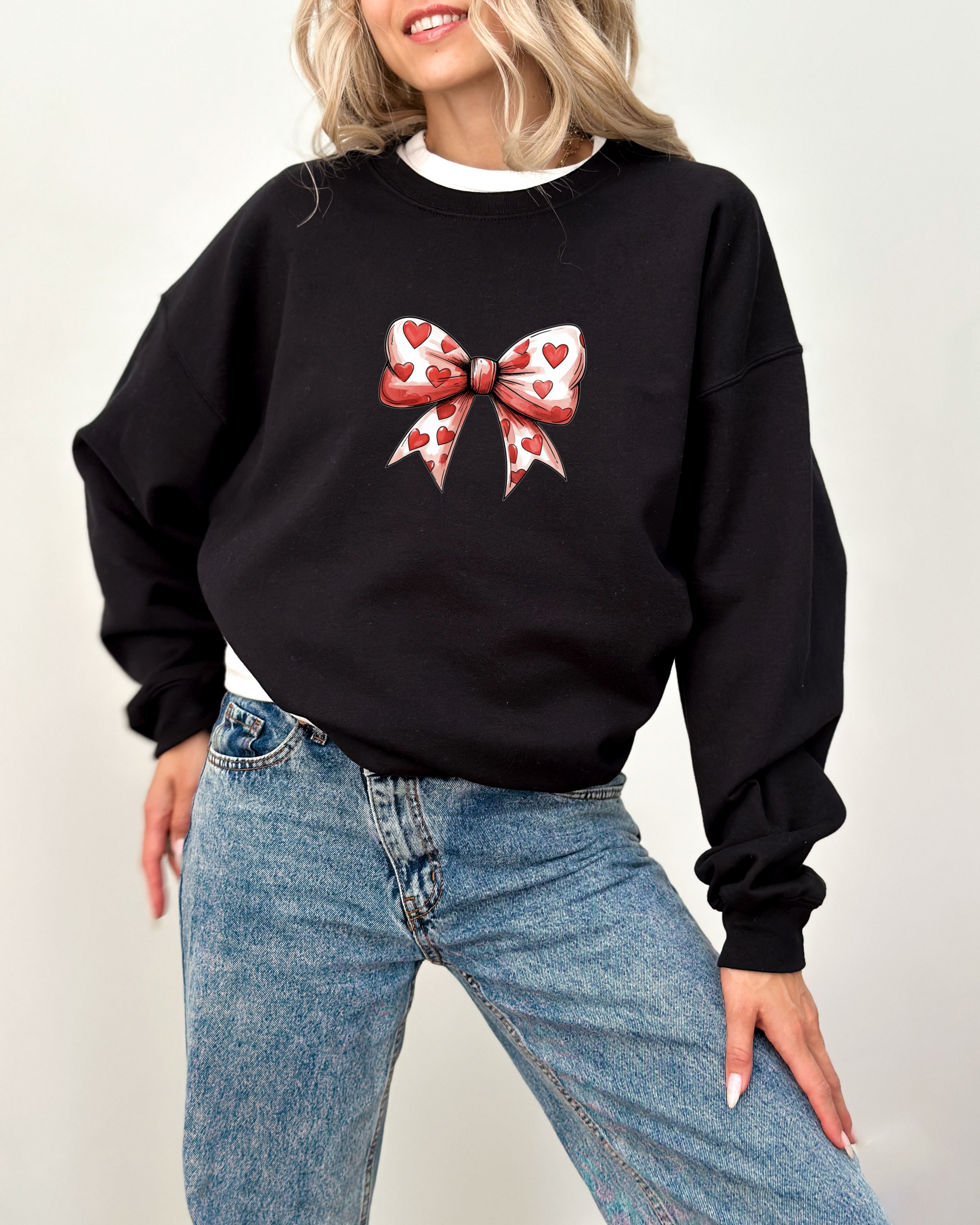 a woman wearing a black sweatshirt with a red bow