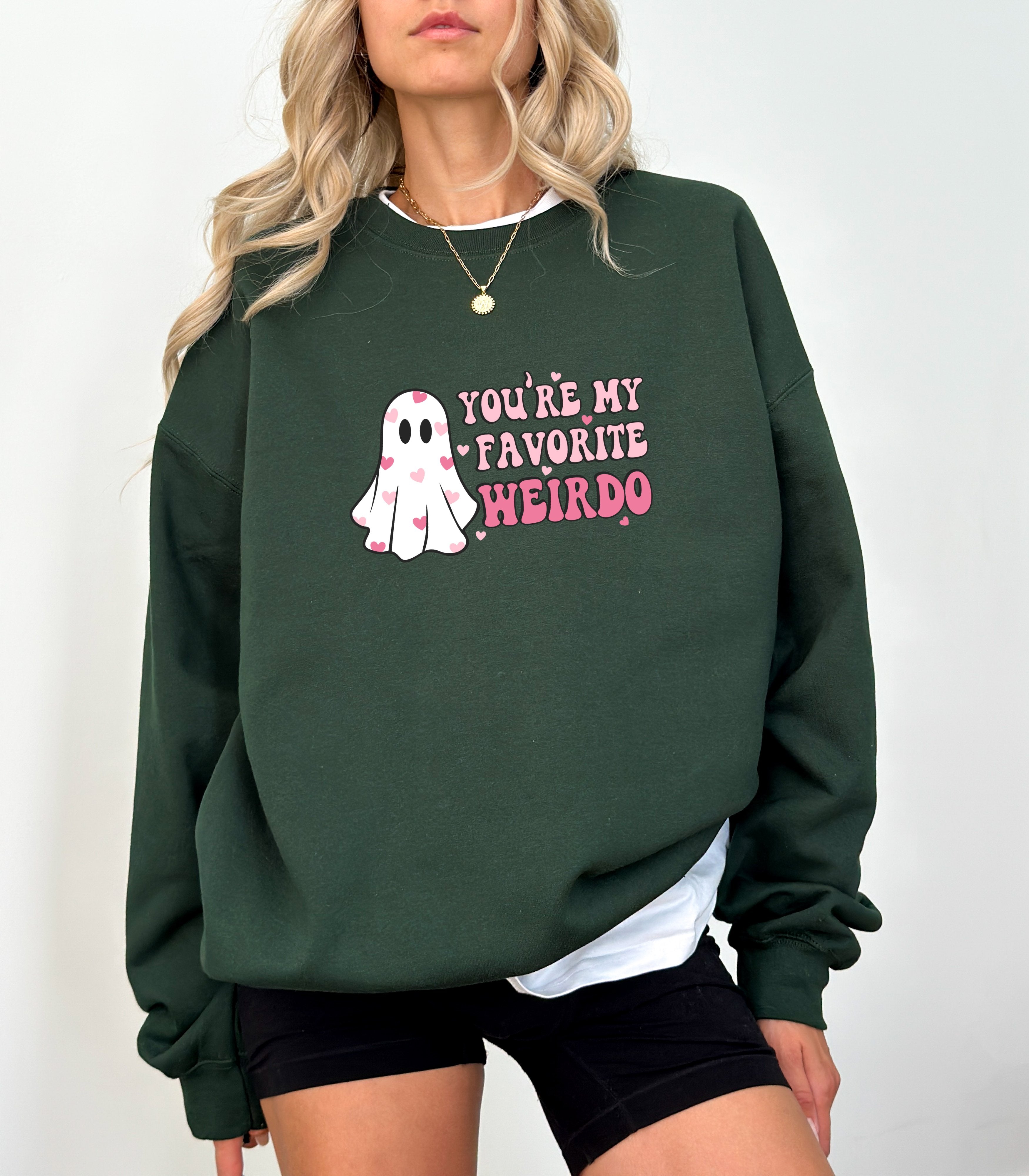 a woman wearing a green sweatshirt that says you're my favorite weirdo