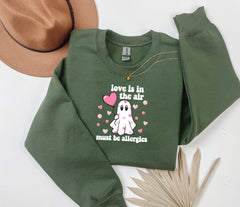 a green sweatshirt with a pink heart on it