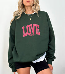 a woman wearing a green sweatshirt with the word love on it