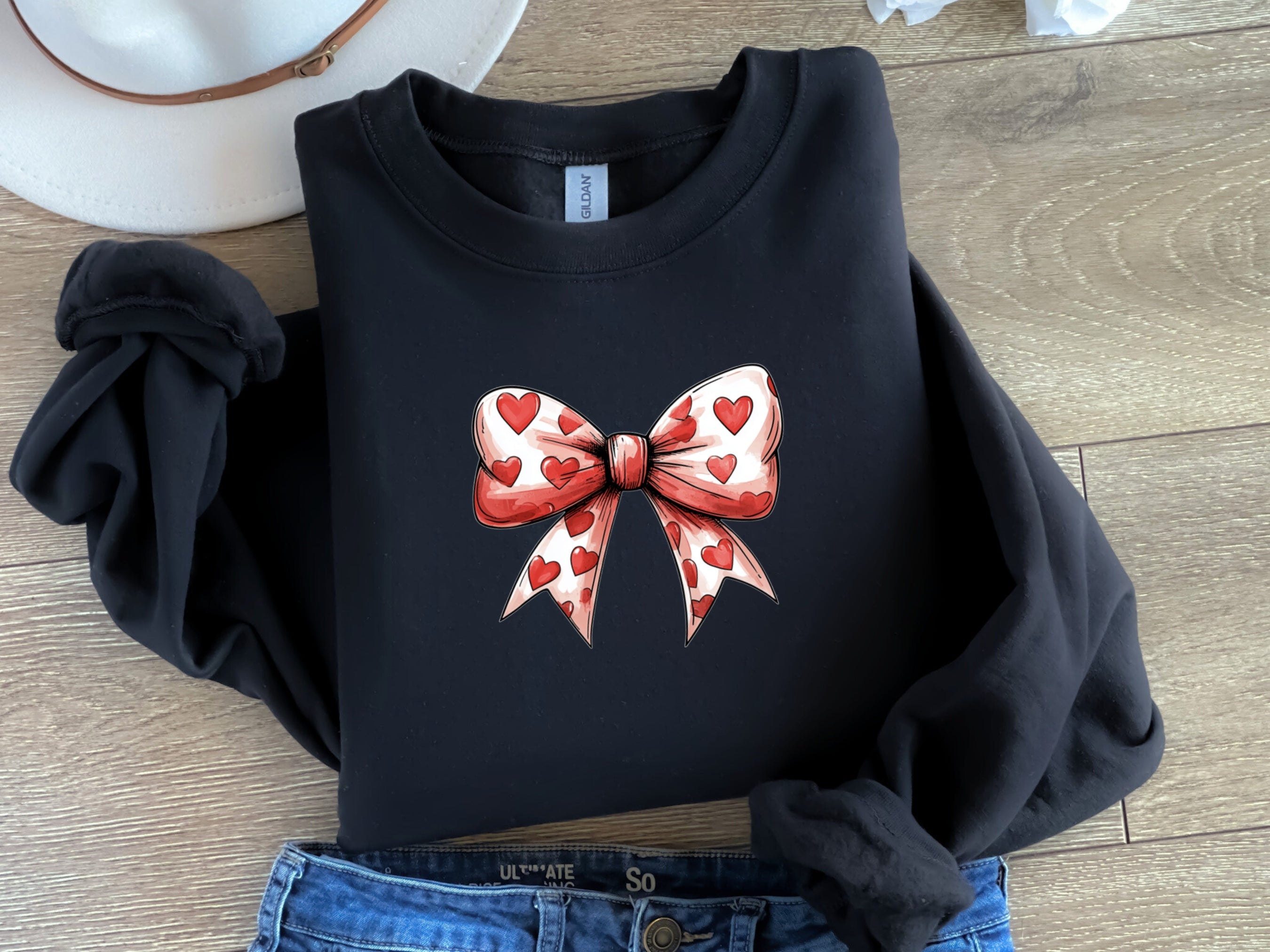 a black shirt with a red bow and hearts on it