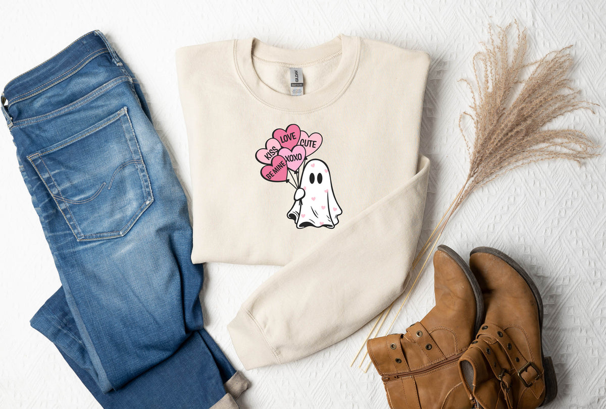 a sweater with a ghost on it next to a pair of jeans