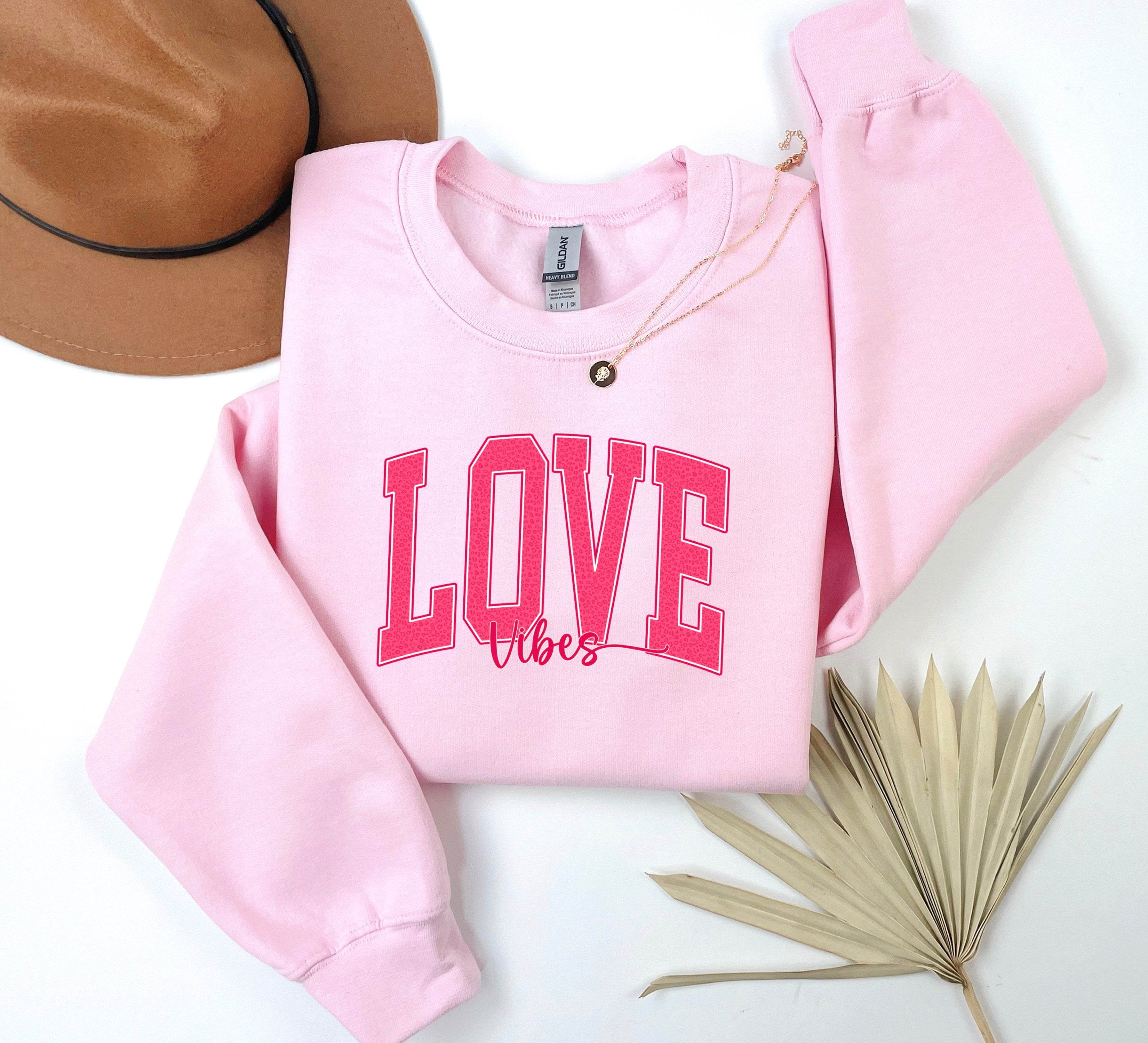 a pink sweatshirt with the word love on it