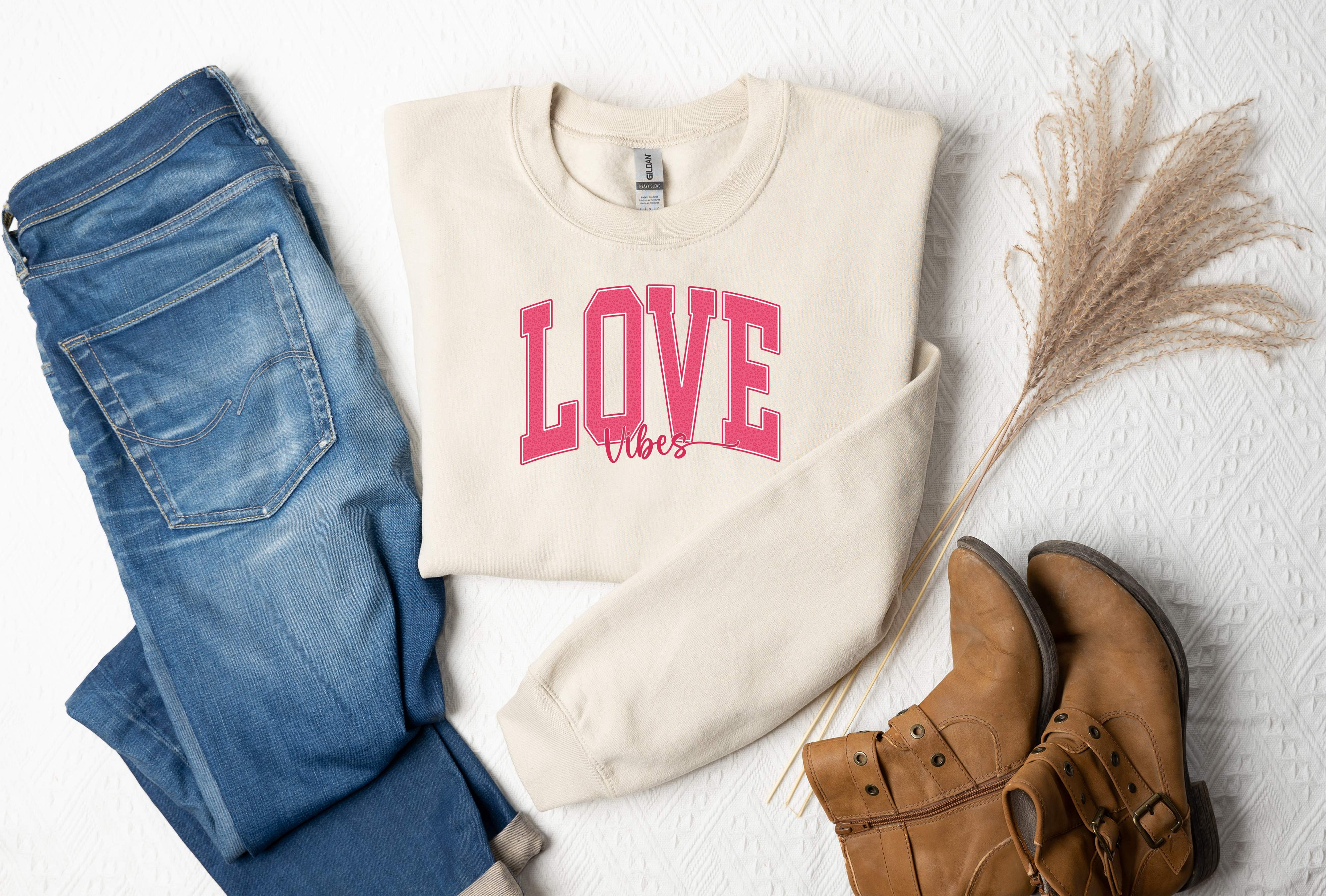 a pair of jeans and a sweater with the word love on it