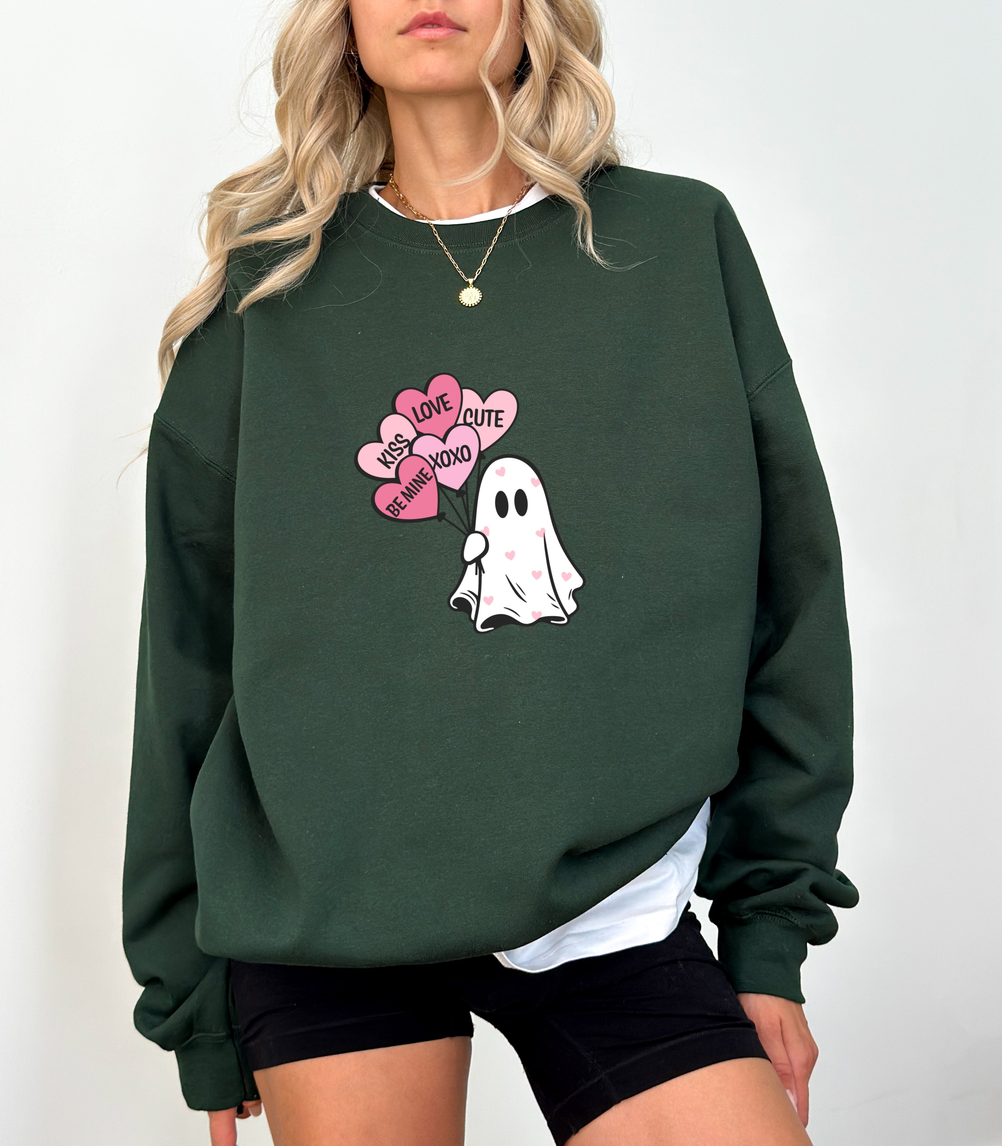 a woman wearing a green sweatshirt with a ghost on it