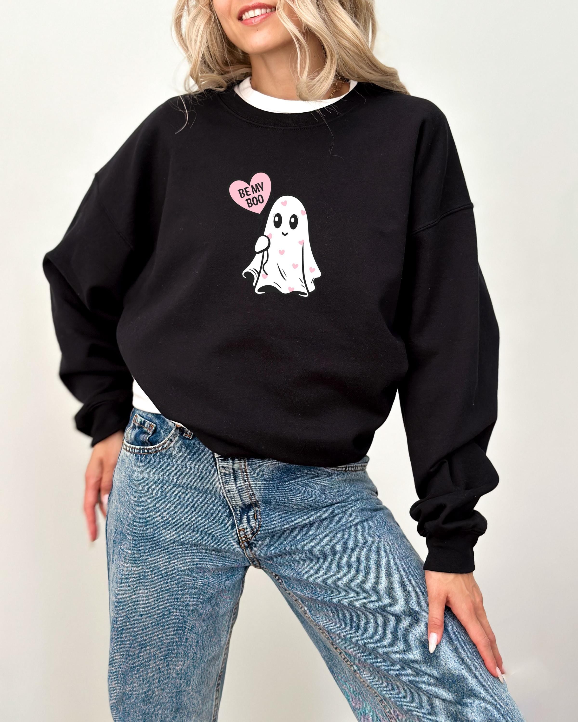 a woman wearing a black sweatshirt with a ghost on it