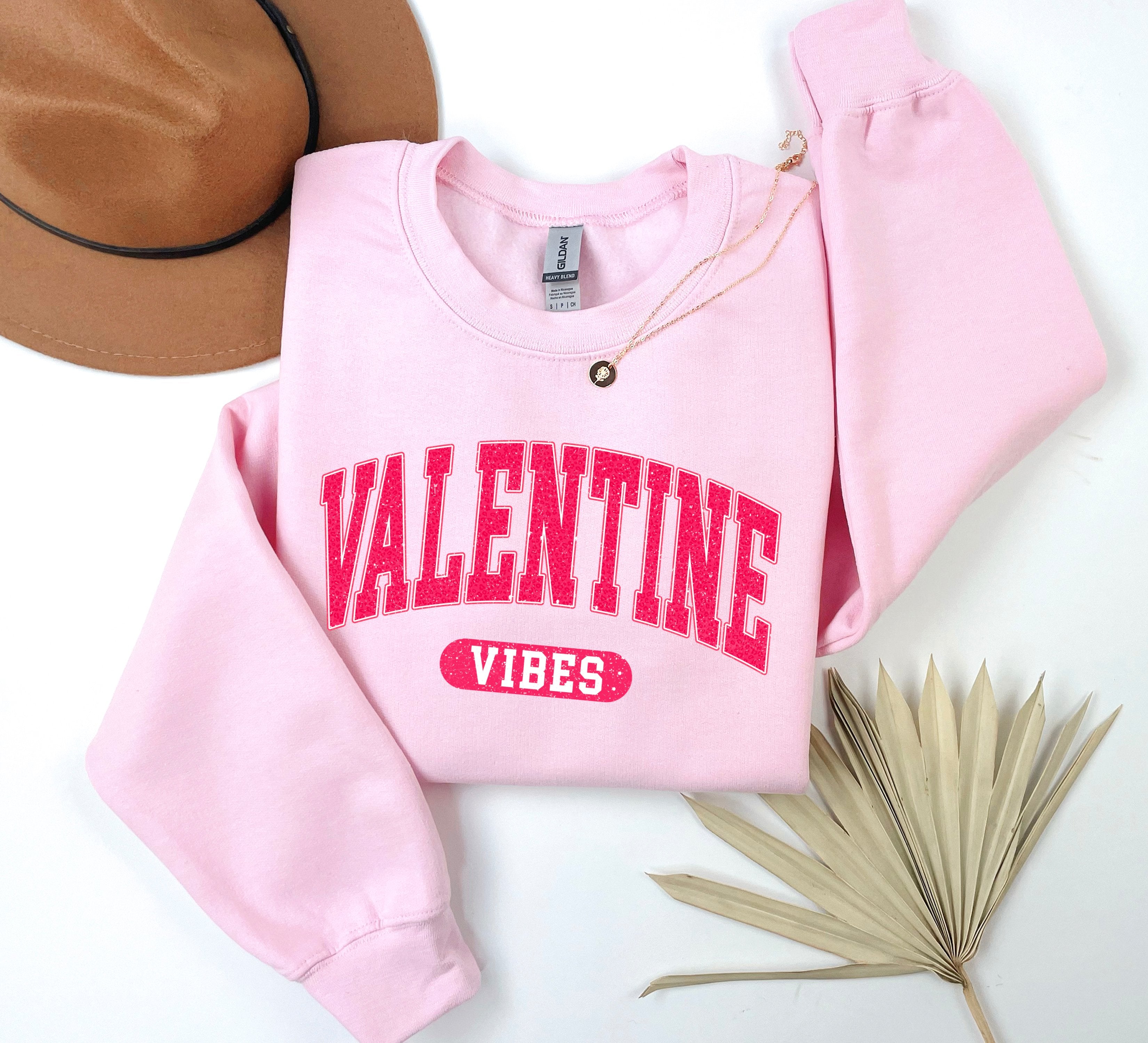 a pink sweater with the word valentine vibes on it