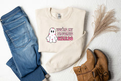 a sweater with a ghost on it next to a pair of jeans