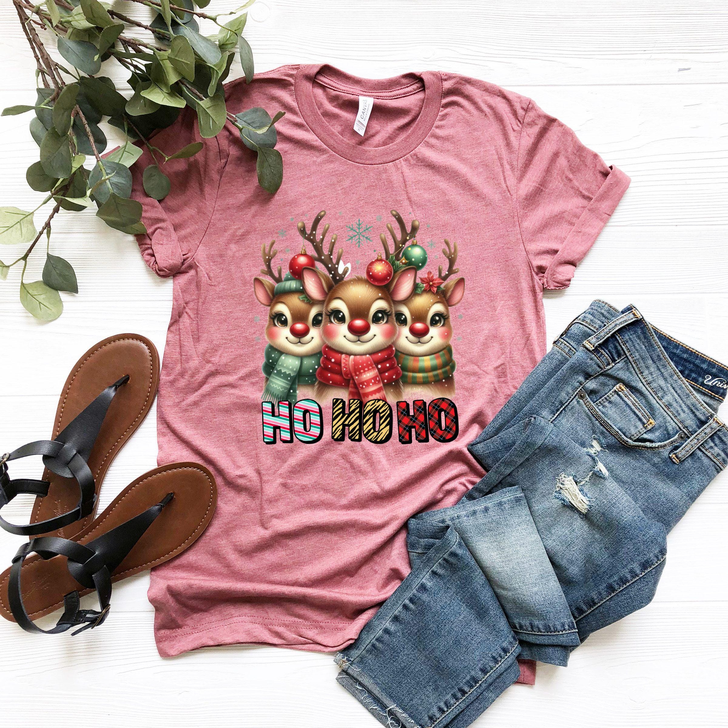 a t - shirt with three reindeers on it next to a pair of jeans