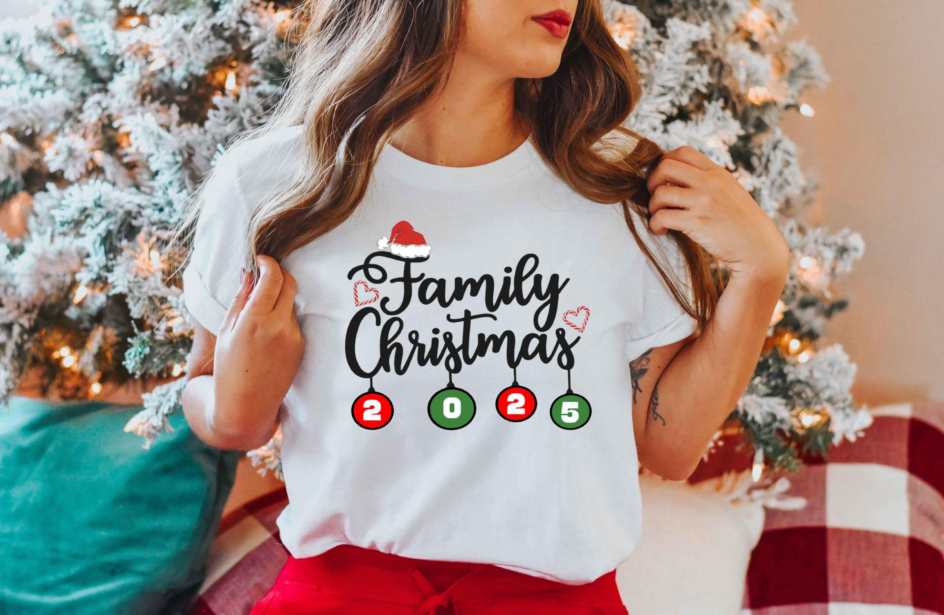 a woman wearing a family christmas t - shirt in front of a christmas tree